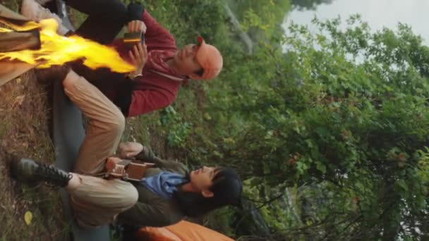 亚洲女人和女友在篝火边玩吉他 享受浪漫时光的垂直镜头 — 图库视频影像