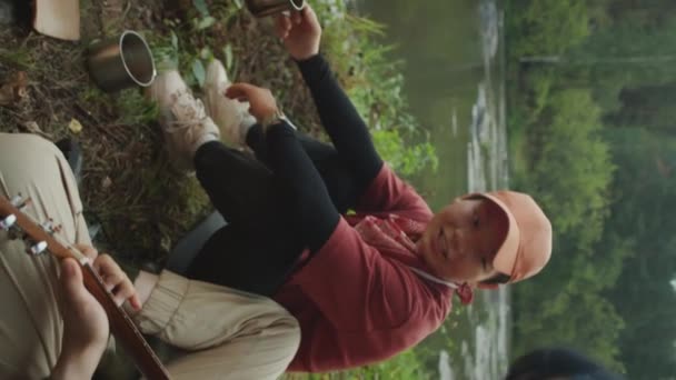 Verticale Panning Shot Van Aziatische Vrouwelijke Toerist Spelen Gitaar Lachen — Stockvideo