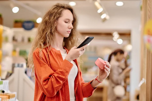 Jovem Cliente Fazendo Foto Creme Smartphone Durante Suas Compras Loja — Fotografia de Stock
