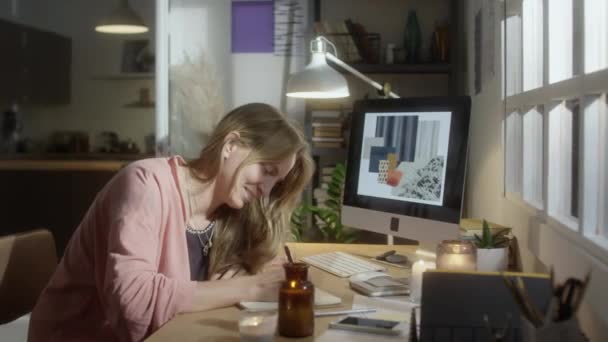 年轻女设计师的画像 她在办公桌前记录下燃烧的蜡烛 然后在舒适的家里工作时摆出姿势拍照 — 图库视频影像