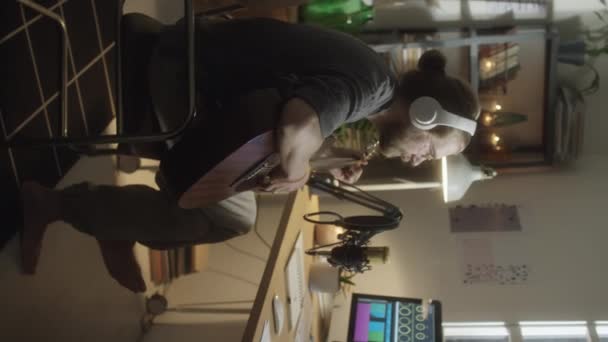 Vertikální Záběr Profesionálního Hudebníka Sluchátkách Hrající Kytaru Zpívající Mikrofonu Při — Stock video