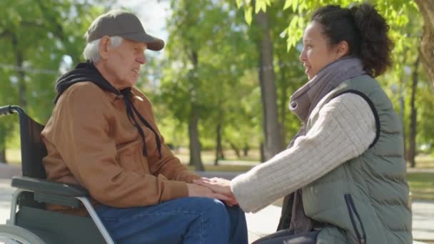 Egy Fiatal Aki Tolószékben Fogja Idősebb Nagyapa Kezét Beszél Vele — Stock videók