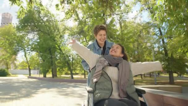 Junge Frau Rennt Und Schubst Aufgeregte Freundin Rollstuhl Während Sie — Stockvideo