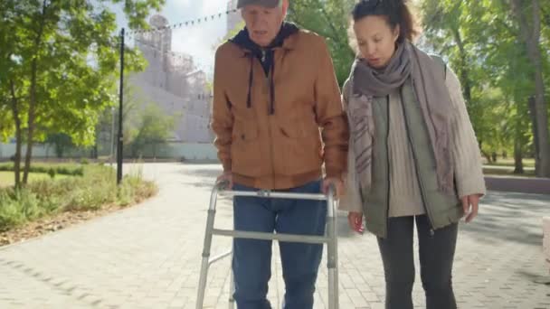 Tilt Shot Female Caregiver Walking Elderly Man Walker Chatting Smiling — Stock Video