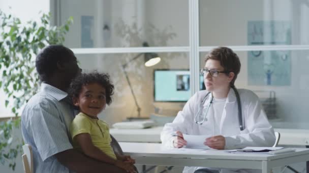 Female Pediatrician Giving Medical Consultation African American Man Little Son — 图库视频影像