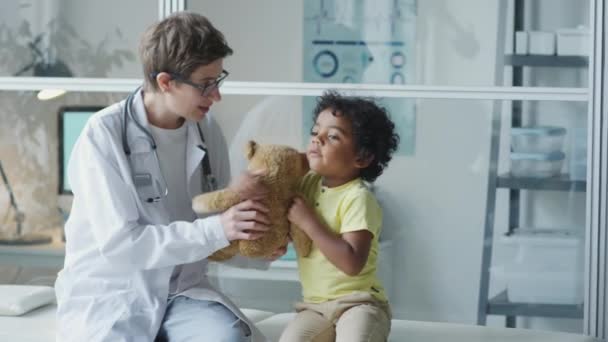 병원에서 소파에 앉아서 장난감과 귀여운 아프리카계 미국인 아이와 이야기 소아과 — 비디오