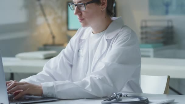 Tilt Shot Female Doctor White Coat Glasses Working Laptop Posing — Video