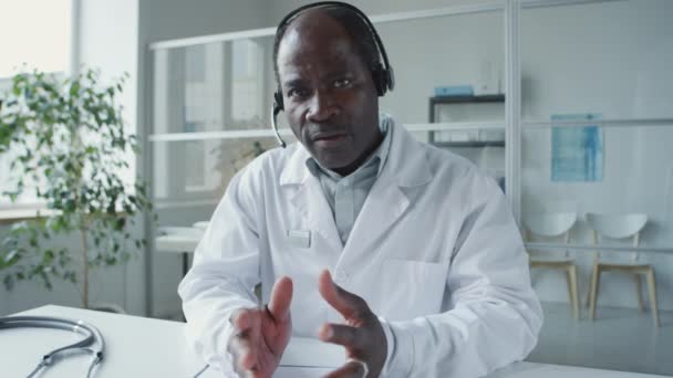 성숙한 아프리카계 미국인 의사의 코트와 헤드셋 카메라를 온라인 상담을주는 통화를 — 비디오