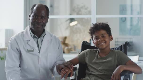 Porträtt Afroamerikansk Läkare Och Pojke Rullstol Som Håller Hand Och — Stockvideo