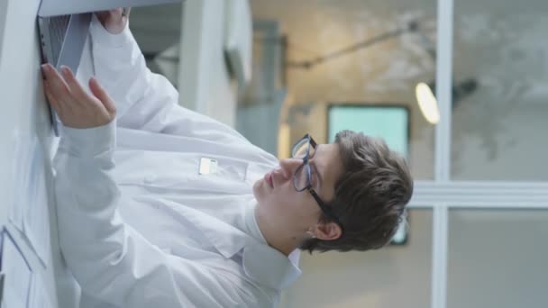 Tiro Vertical Jovem Médica Casaco Branco Óculos Trabalhando Com Documentos — Vídeo de Stock