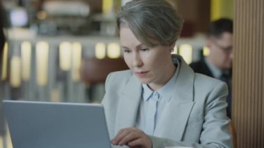 Restoranda kahve molası verirken iş kadınının laptopta çalışmasını çek.
