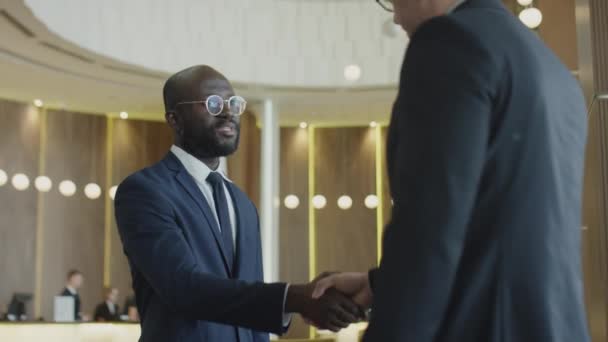 Medelbild Afroamerikansk Affärsman Hälsning Kaukasiska Kollega Hotellobbyn Med Handslag Och — Stockvideo