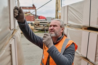 İşçi dışarıda askıları olan yerel büyük kutuyu geri sarıp bir araya getiriyor.