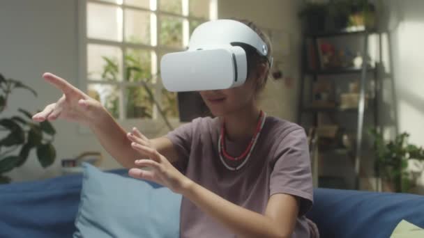 Vrヘッドセットのティーンガールは 自宅で拡張現実ゲームをプレイしながら空気中に何かをキャッチ — ストック動画