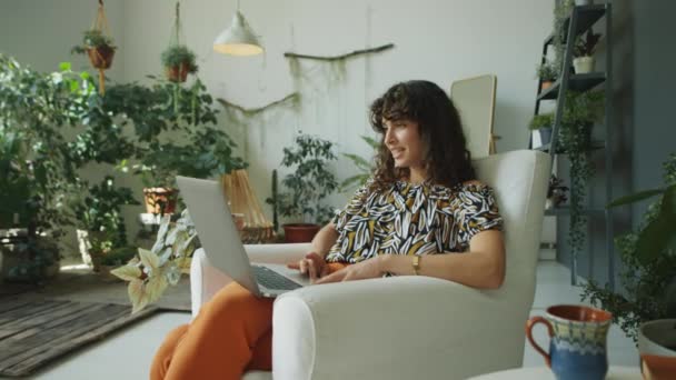 식물로 꾸며진 의자에 노트북에 통화를 여자의 — 비디오
