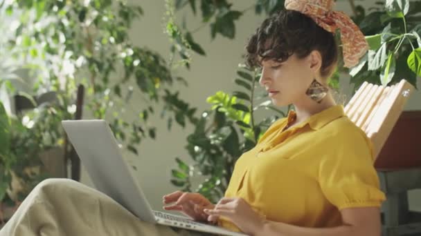 Güzel Bir Kadının Bahçedeki Koltukta Oturup Dizüstü Bilgisayarla Çalışırken Orta — Stok video