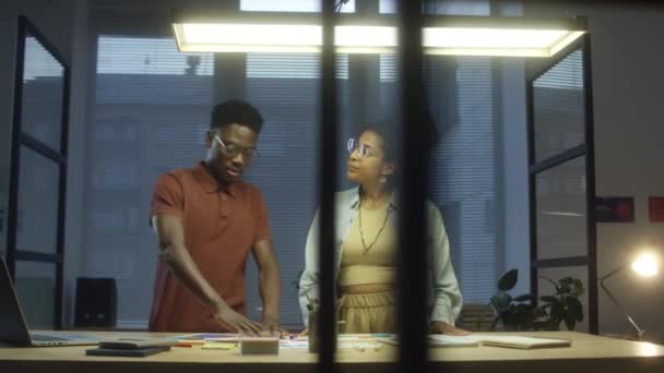 拉丁美洲妇女和非洲裔美国男子在一起执行有创意的工作计划时使用粘贴的字条 — 图库视频影像