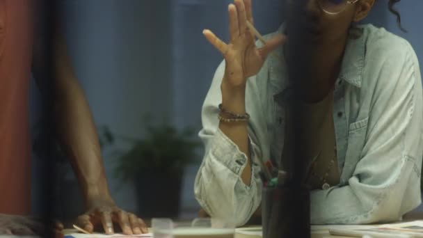 노트를 히스패닉 여자와 아프리카계 미국인 남자의 기울이고 사무실에서 창조적인 프로젝트를 — 비디오