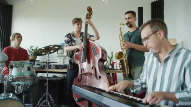 一组人在录音室用合成器 双簧管 萨克斯和鼓演奏现场爵士音乐 — 图库视频影像