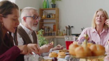 Yaşlı çift evde Paskalya yemeği yerken kızlarıyla sohbet ediyor.