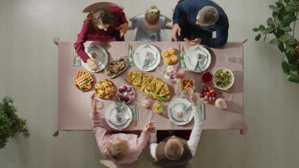 复活节那天 一家人手牵手祈祷 然后在饭桌上享用节日大餐的自上而下的镜头 — 图库视频影像