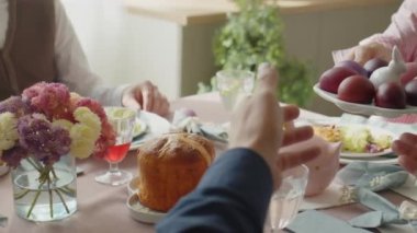 Paskalya günü şenlikli bir akşam yemeği yerken baba ve küçük kızına boyanmış yumurta tabağı uzatıyor.