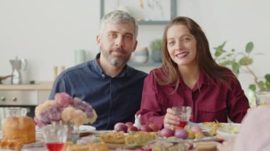 Paskalyayı ailemle kutlarken yemek masasında kameraya poz veren güzel bir çift portresi.