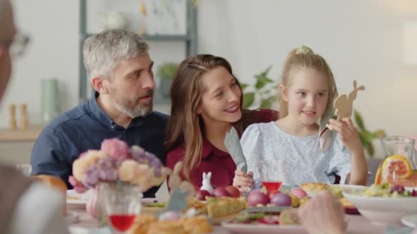 Para Rodzin Rozmawia Uroczą Córeczką Podczas Zabawy Zabawkami Wielkanocnej Kolacji — Wideo stockowe