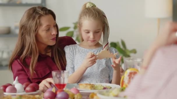 复活节家宴上 小女孩和妈妈坐在餐桌旁玩木兔玩具 — 图库视频影像