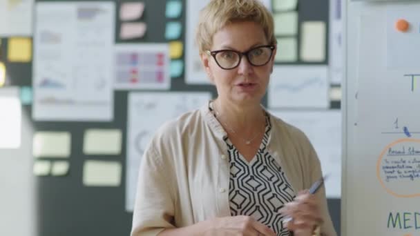 Vrouwelijke Bedrijfstrainer Wijst Naar Flipchart Geeft Bedrijfspresentatie Terwijl Het Verstrekken — Stockvideo