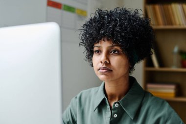 Sınıfta bilgisayarla çalışan genç Afrikalı Amerikalı öğretmen.