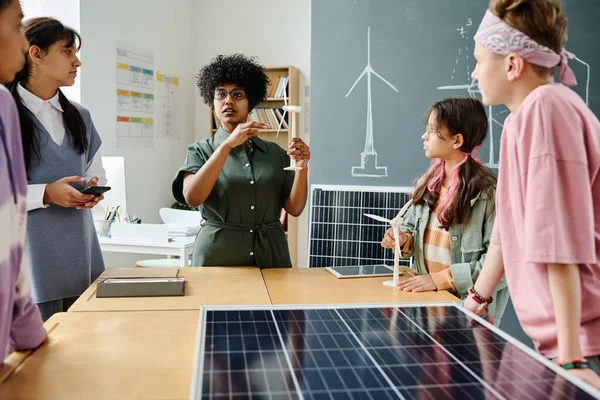 Öğrencilere ders sırasında yel değirmeninin çalışmalarını açıklayan Afrikalı Amerikalı öğretmen