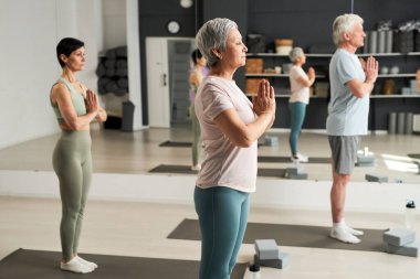 Yoga dersinde birlikte meditasyon yapan bir grup insan.