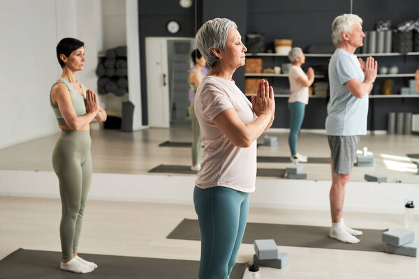 Group of people meditating together during training in yoga class