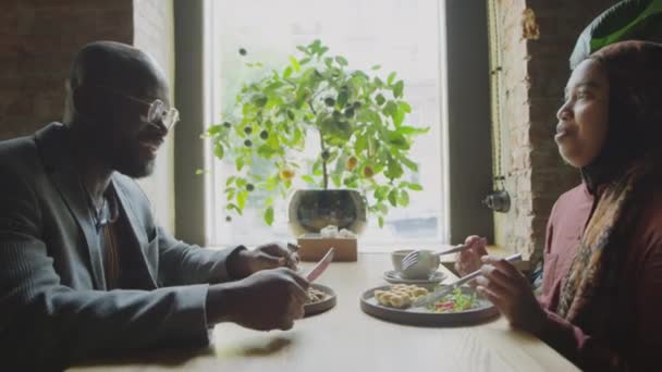 Oldalnézet Muszlim Üzletasszony Hidzsáb Afro Amerikai Férfi Asztalnál Kávézóban Eszik — Stock videók