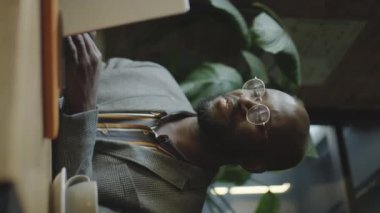 Afro-Amerikalı iş adamının kahve masasında otururken bilgisayardan yaptığı görüntüler.
