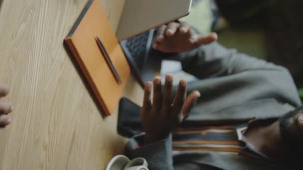 Pionowe Ujęcie Afroamerykanina Biznesmena Siedzącego Laptopem Kawą Przy Stoliku Kawiarni — Wideo stockowe