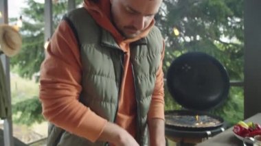 Yemek blogcusu kırmızı lahanayı bıçakla öğütüyor ve kamera önünde konuşurken açık terasta online yemek pişirme ustası dersi veriyor.