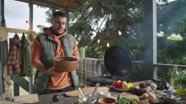 在户外烧烤平台上举办烹饪大师课程的同时 博客作者还在镜头前讲述菜谱 并在碗中展示红色卷心菜片沙拉 — 图库视频影像