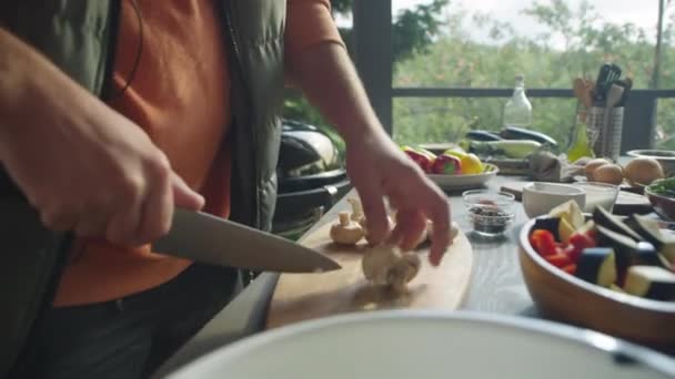 屋外テラスでバーベキュー用の野菜を準備しながら 木製のボード上の新鮮なチャンピオンを切断する男の手のクロップショット — ストック動画