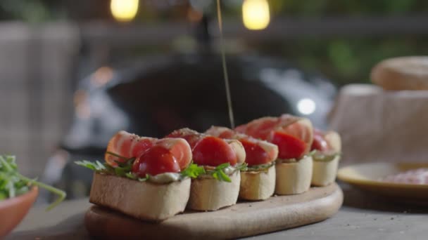 ベーコン アルギュラ トマトをベーコンでブロシェッタの上にオリーブオイルを注ぐ選択的な焦点ショットを閉じる — ストック動画