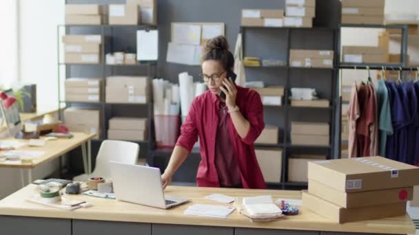 Kadın Telefonda Konuşuyor Laptopunu Kullanıyor Teslimat Servisinde Çalışırken Postaları Kontrol — Stok video