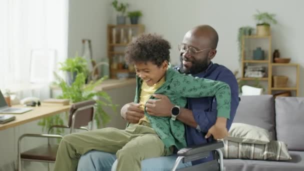 Mediana Toma Padre Afroamericano Silla Ruedas Haciendo Cosquillas Pequeño Hijo — Vídeos de Stock