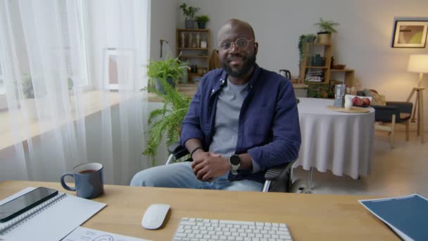 Hombre Afroamericano Sentado Silla Ruedas Escritorio Sala Estar Hablando Cámara — Vídeos de Stock