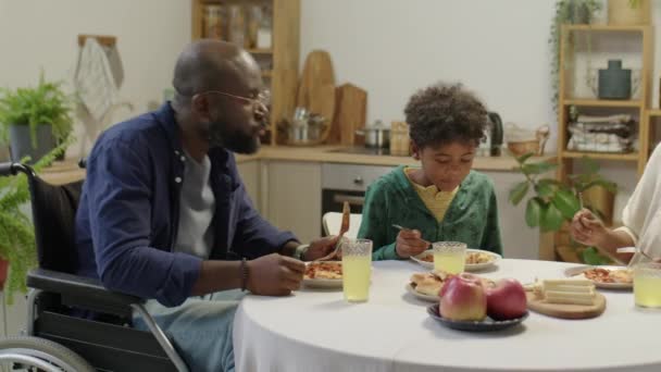 Medelhög Bild Afroamerikansk Pappa Rullstol Äta Måltid Och Tala Med — Stockvideo