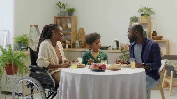 휠체어에서 아프리카계 미국인 여성의 식사를 집에서 식사를 아들과 남편과 — 비디오