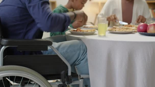 Tekerlekli Sandalyede Ailesiyle Akşam Yemeği Yiyen Afro Amerikan Bir Adam — Stok video