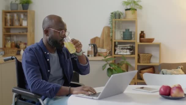 Medium Bild Afroamerikansk Man Rullstol Dricka Juice Och Skriva Laptop — Stockvideo