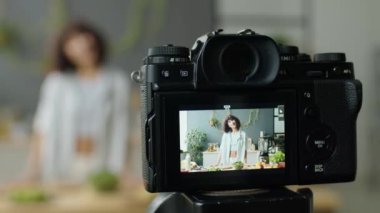 Mutfakta yemek blogcusu tarifini anlatırken tripodun dijital kamerasının seçmeli odak noktası.