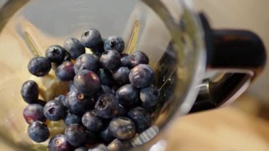 Buzlu meyve püresi yapmak için mutfak blendırında taze yaban mersininin en üst görüntüsünü kapat.